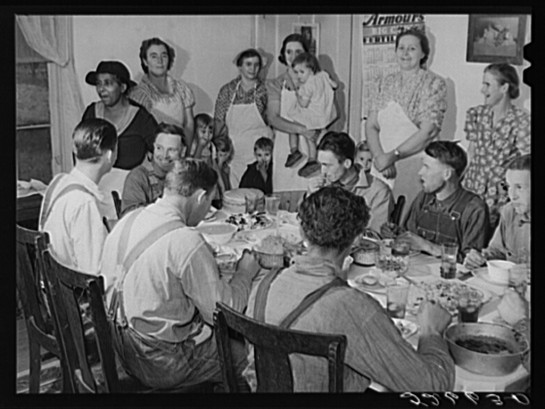 After the corn shucking, women and children of the Wilkins family gather around while the men eat. 